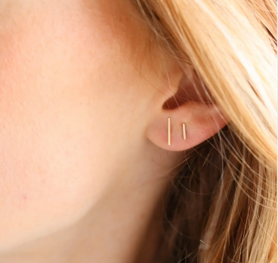 Model wearing 14k gold fill bar studs