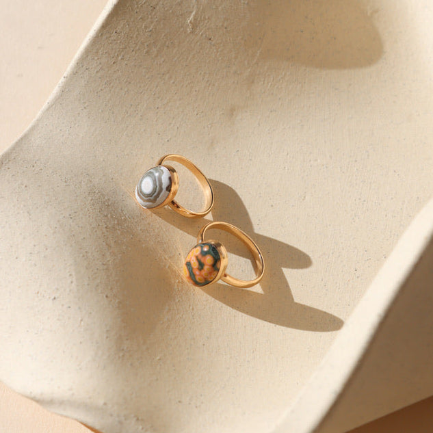 14k gold fill rings with oval ocean jasper stones on a light dish