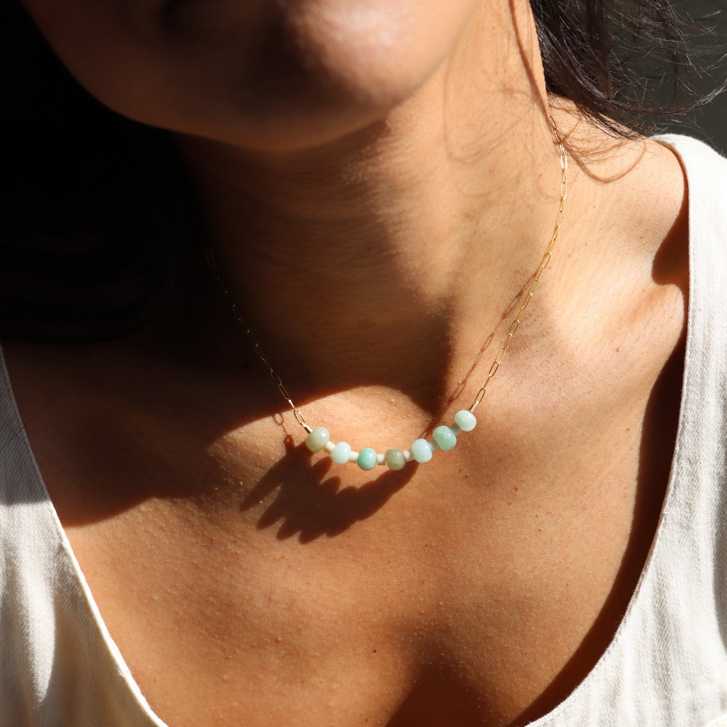 model wearing 14k gold fill paperclip chain with fossil jasper and jade beads