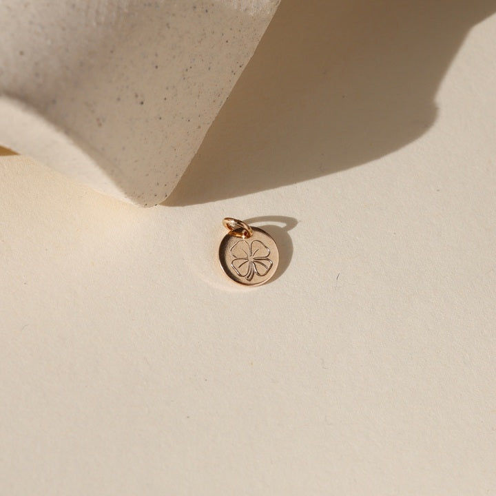 14k gold fill disk with shamrock hand stamped on a light background