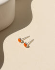 Sienna Studs featuring 4mm fiery orange spiny oyster cabochons in sterling silver bezel settings.