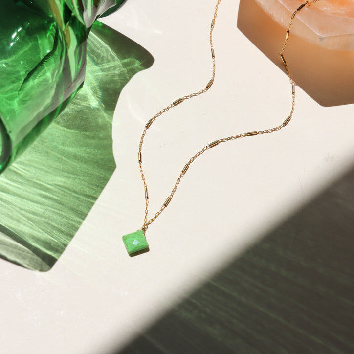 14k gold fill chain necklace with gaspite stone on a light surface