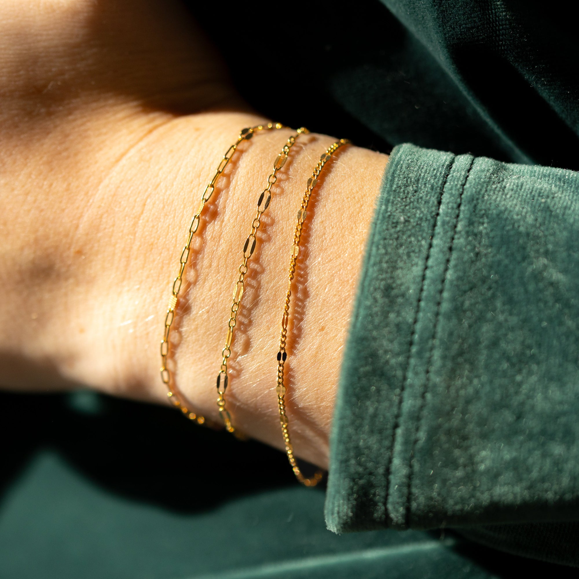 Gold sunburst chain bracelet with delicate textured links that catch the light.