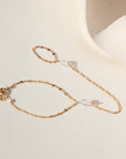 Gold sunburst hand chain featuring delicate textured links and a raw Herkimer diamond accent.