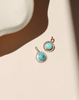 14k gold fill and sterling silver charms with round turquoise stones in the sunlight