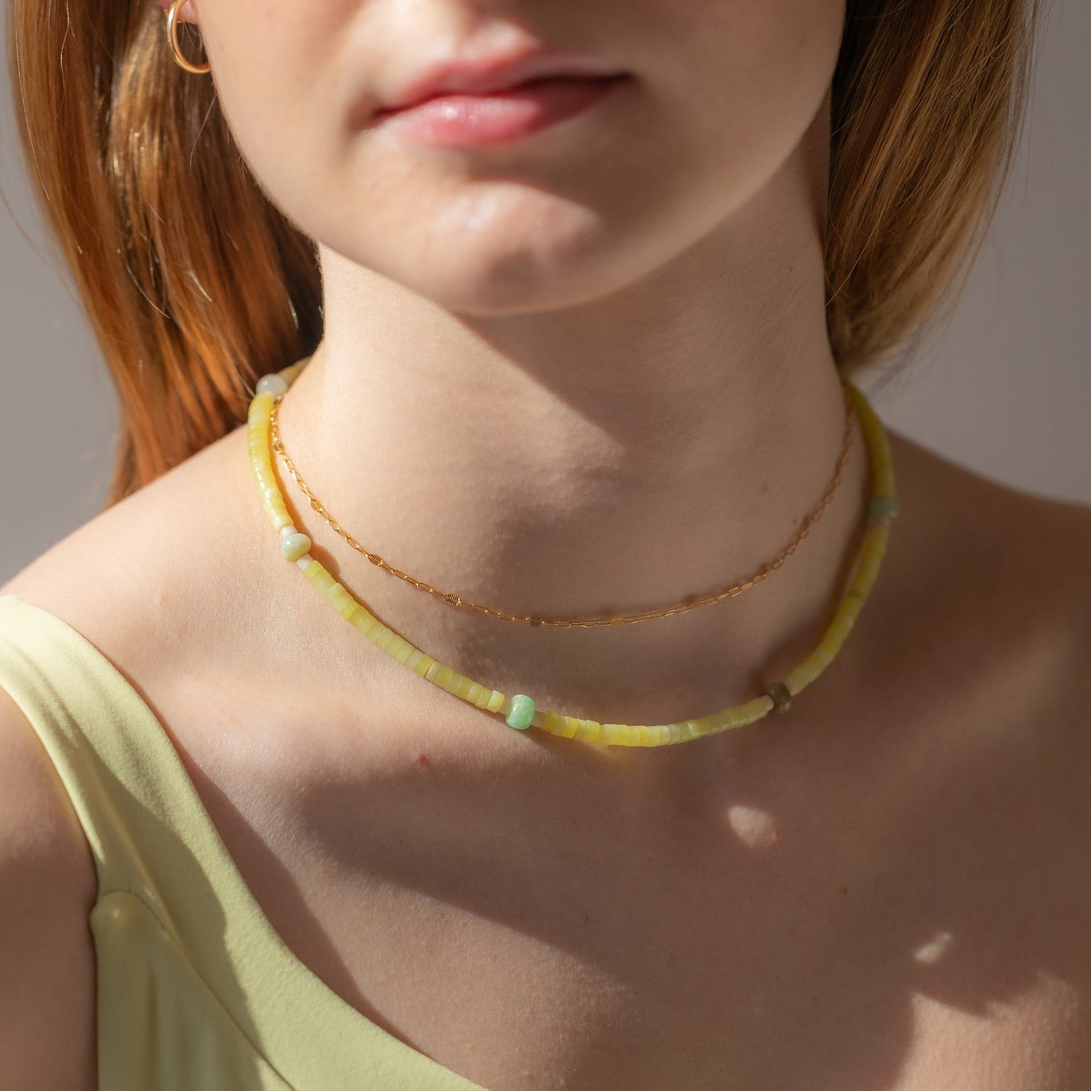model wearing 14k gold fill chain necklace with a jade & fossil jasper beaded necklace