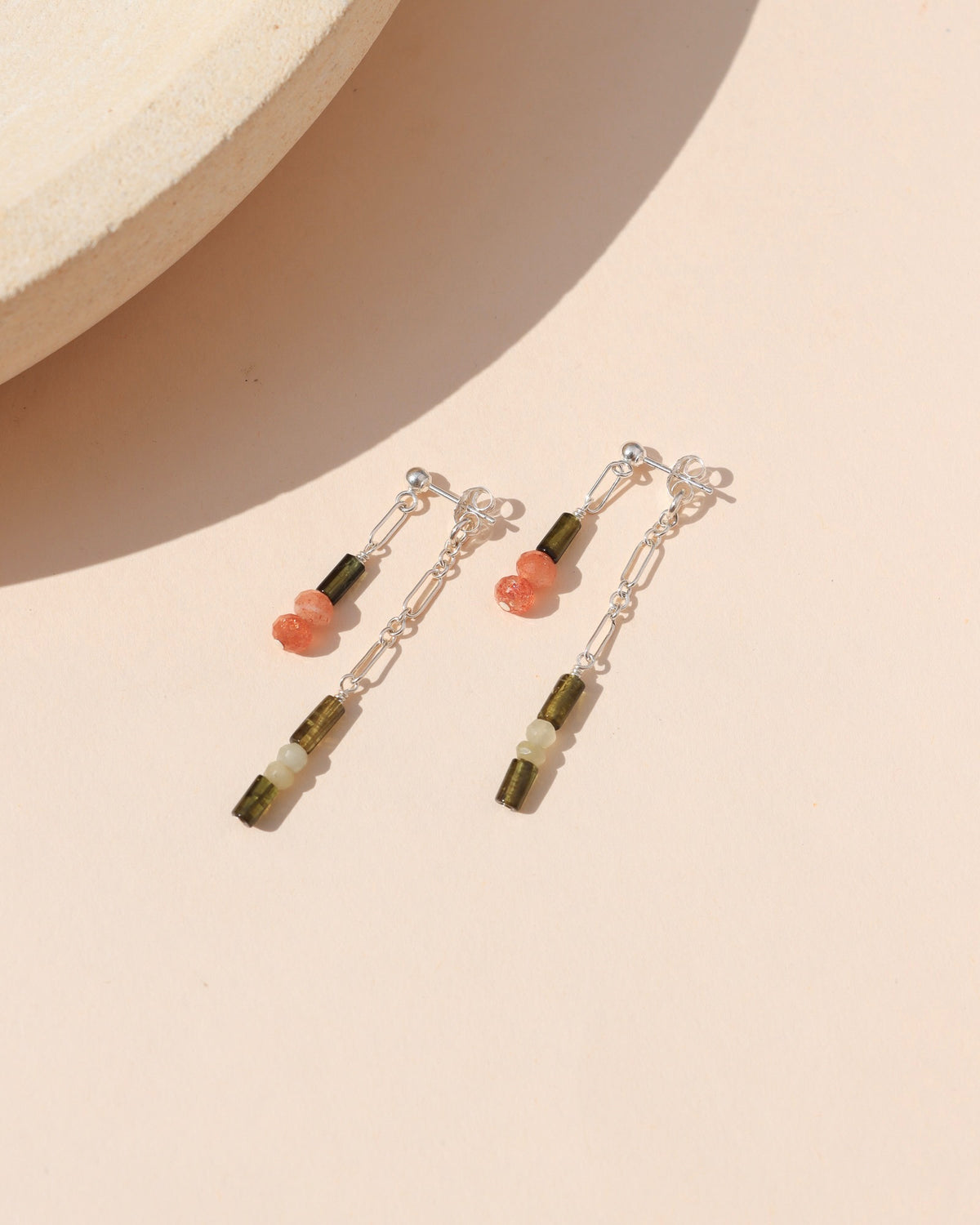 Sterling silver mismatched drop earrings with delicate chain links and green, white, and peach gemstone beads.
