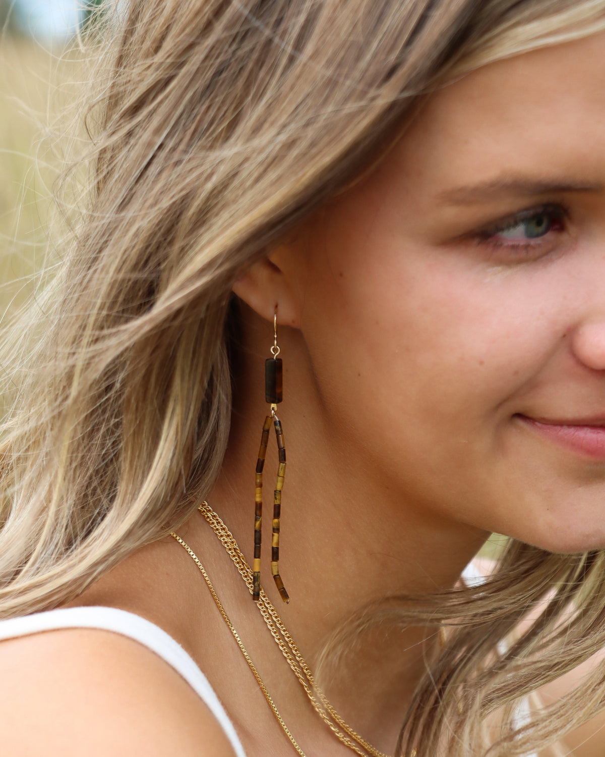 Long drop earrings featuring warm brown and golden rectangular gemstone beads suspended from delicate gold ear wires.