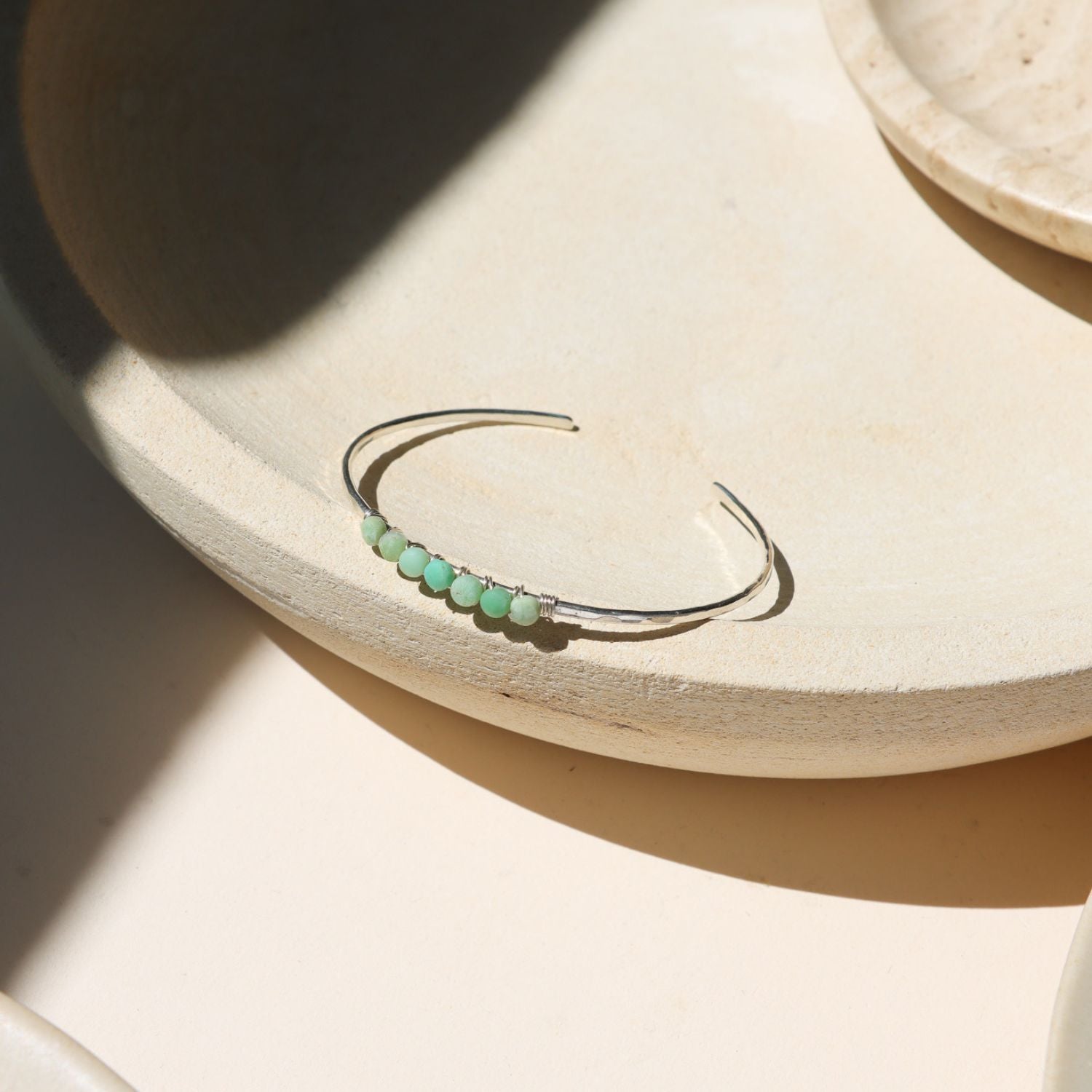 sterling silver cuff with wire wrapped chrysoprase stones in the sunlight