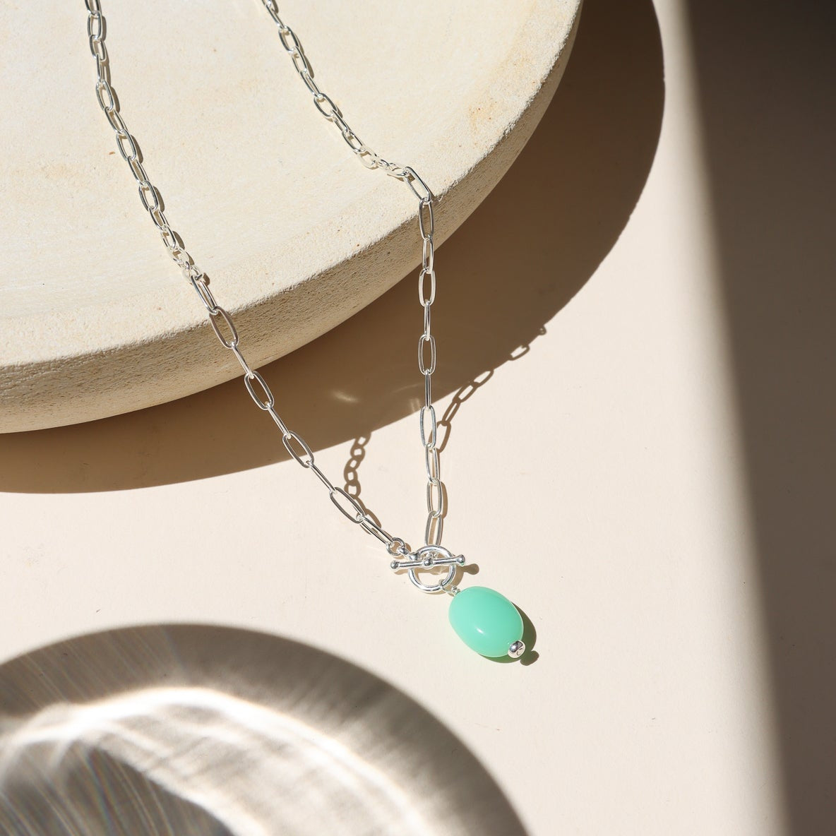 sterling silver paperclip chain necklace with toggle clasp and chrysoprase stone in the sunlight
