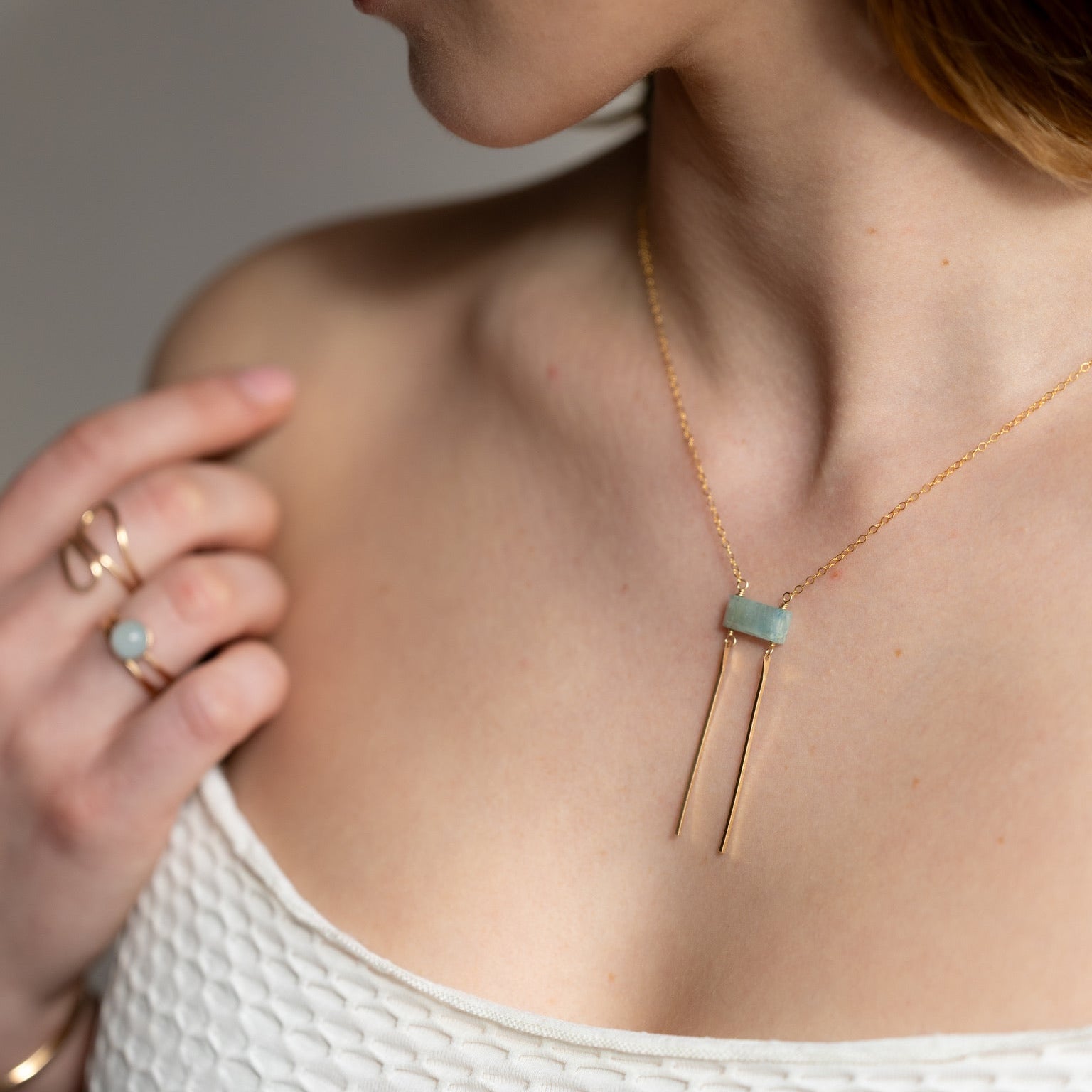 model wearing 14k gold fill chain necklace with aquamarine stone and bars