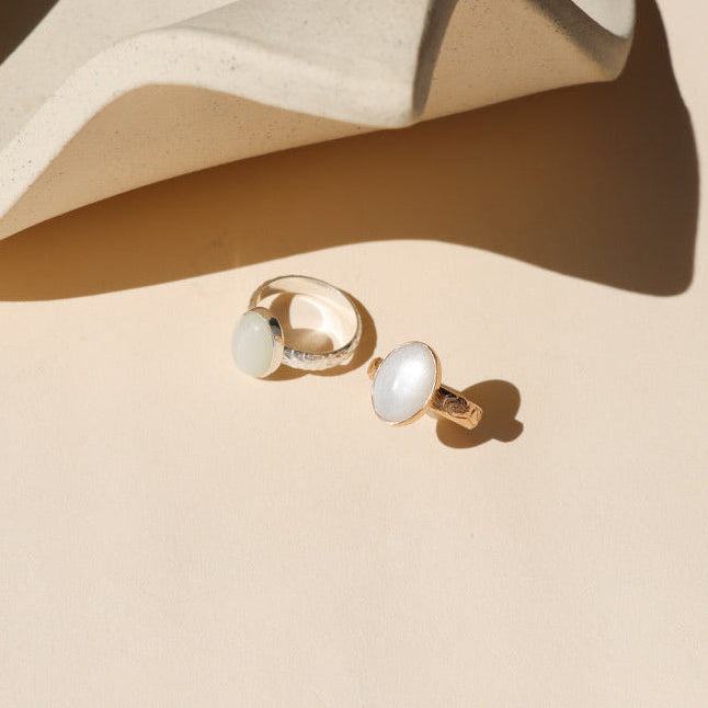 sterling silver and 14k gold fill floral band ring with oval moonstone on a light table