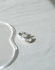 925 sterling silver 3/4" hoop earrings featuring a wave texture photographed on a white tabletop