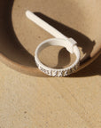 Ring sizer laid on a tan plate in the sunlight. You don't know that size you need for your finger order this to help you find the perfect fit.